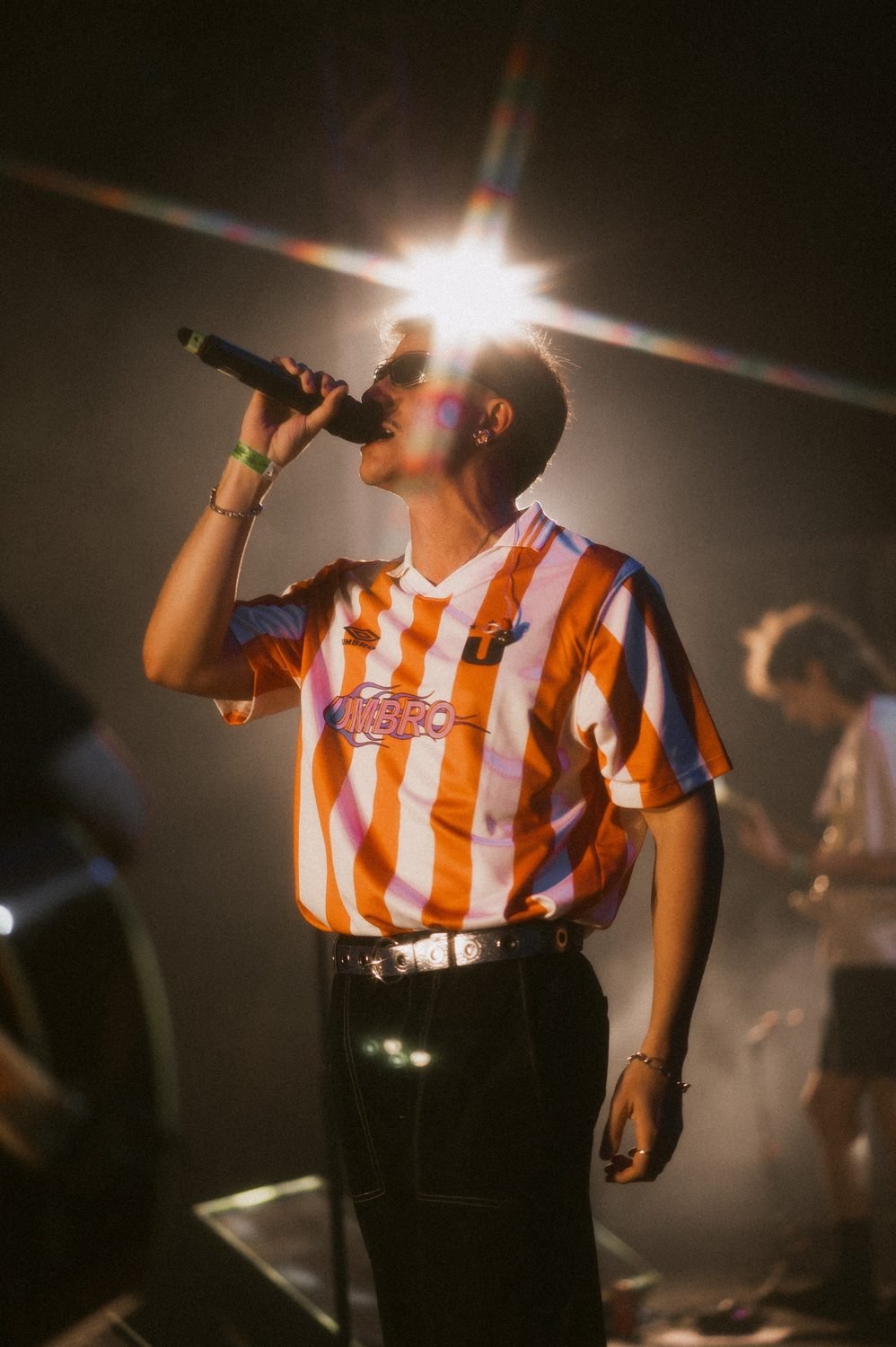 Lucas Gavvi singing into the mic under stage lights